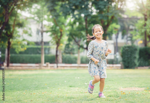 Portrait of happy young Asian girl enjoy running put outdoor at the park