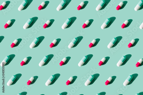 Pattern made with medicine pills on bright pastel light blue background. Medicine and pharmacy creative concepts. Trendy colors.