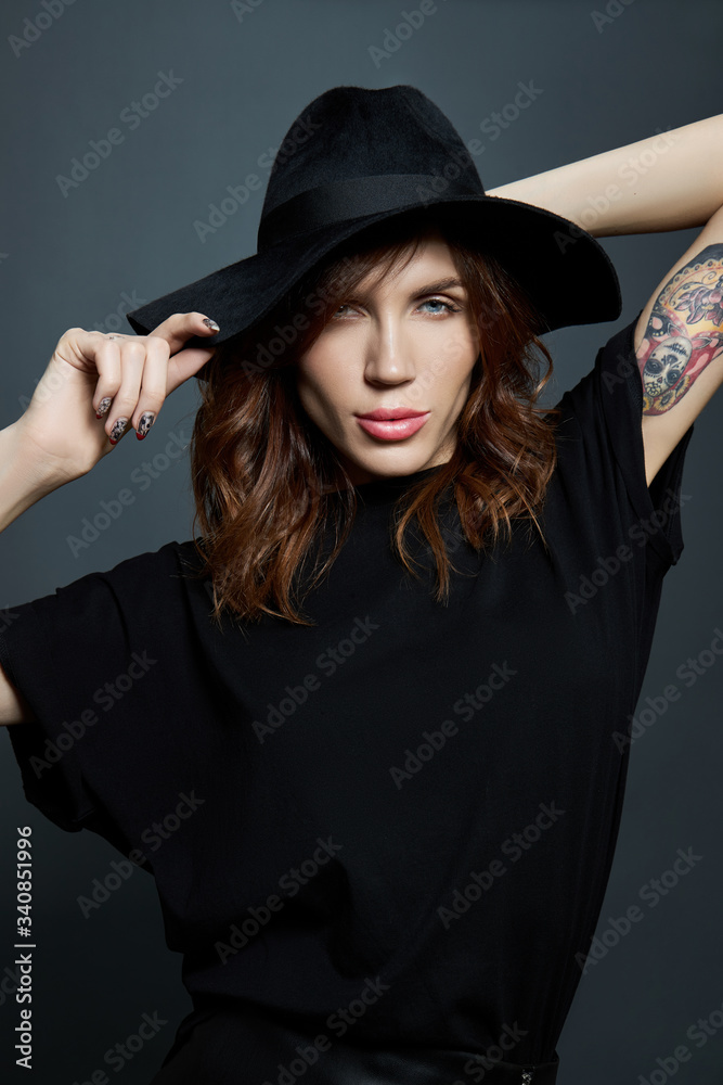Portrait of a woman in a large black hat on a dark background Portrait of a woman in a large black hat on a dark background