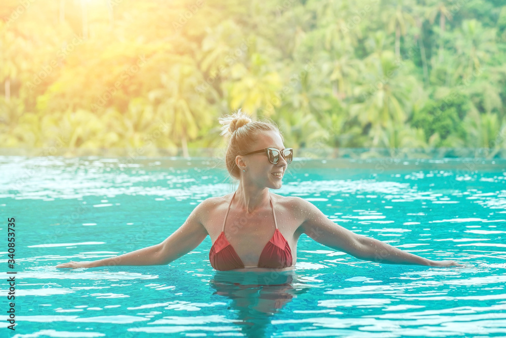 Happiness woman traveler in bikini in water pool near sea coastline 