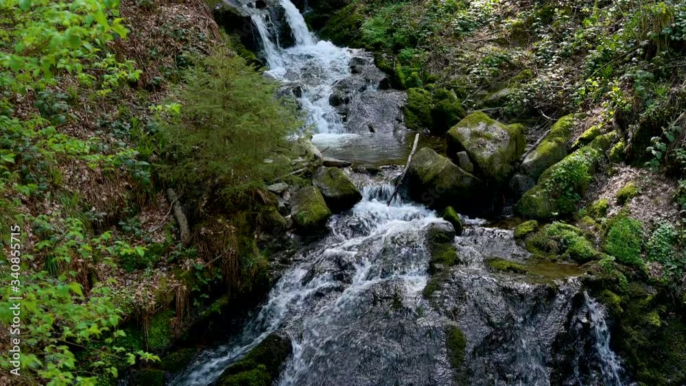 Tracking shot of a cascade waterfall in the Black Forest in a beautiful landscape in the spring with real sound Tracking shot of a cascade waterfall in the Black Forest in a beautiful landscape in the spring with real sound