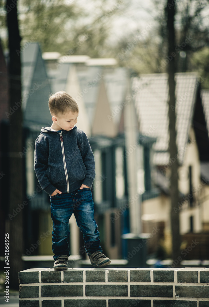 offended little stylish boy outdoors