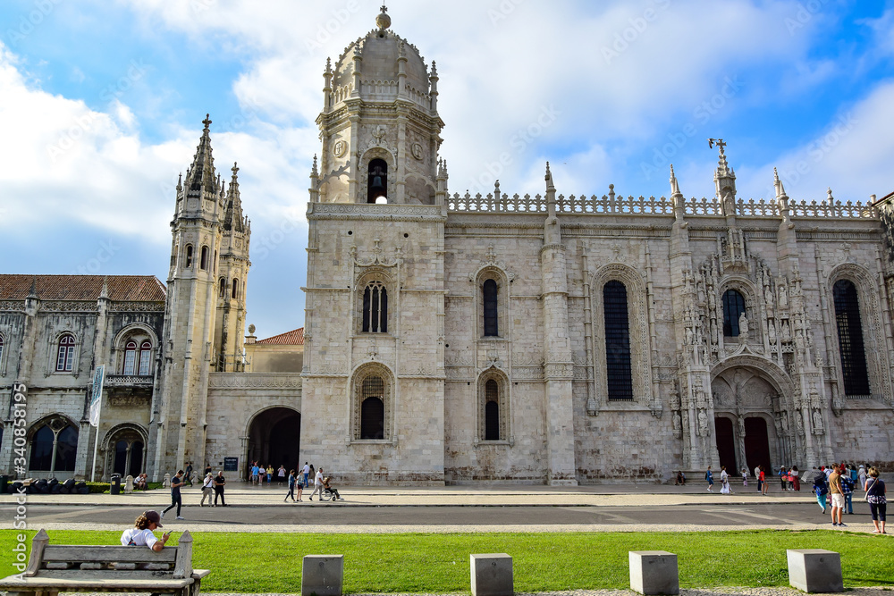 Lisbon, Portugal - Monastery of the Hieronymites (Mosteiro dos Jerónimos), a white-gray stone structure, a monument of late Gothic manueline style of Portuguese architecture, blue sky.