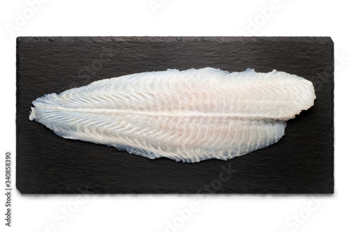 Basa fish fillet on a black stone plate, Isolated on white background, Top view. photo