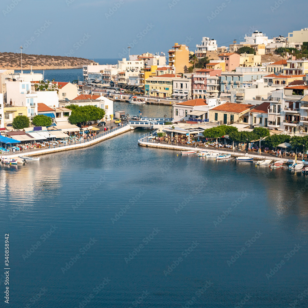 top view of a quiet bay and the Greek resort town of Agios Nikolaos on a sunny summer day