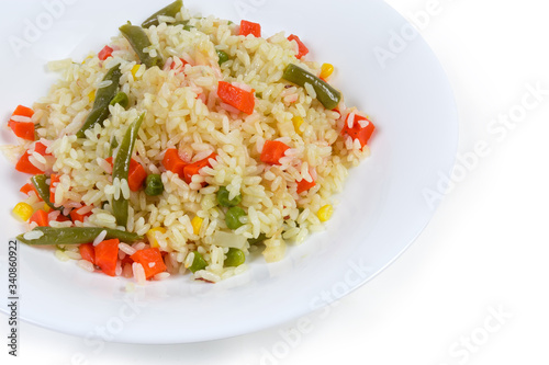 Rice boiled with vegetables on the white dish close-up