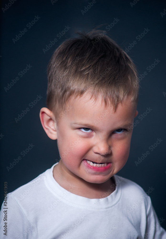 offended and nervous boy on gray background offended and nervous boy on gray background