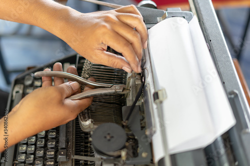 Close up photo of vintage manual typewriter being fixed by a repairman 
