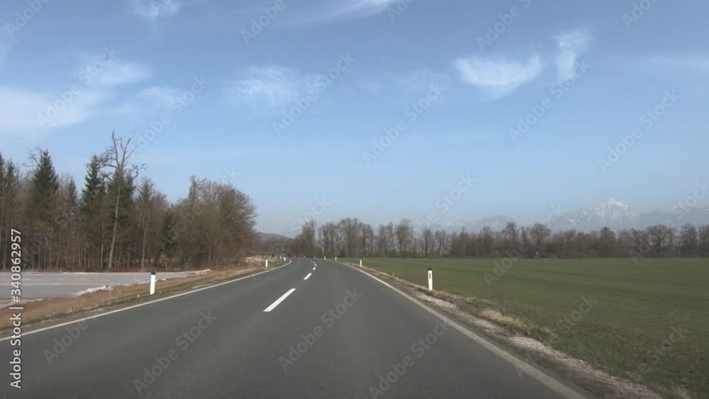 POV Point of view driving on empty countryside road in Slovenia. Ljubljana basin with Alps mountains in background POV Point of view driving on empty countryside road in Slovenia. Ljubljana basin with Alps mountains in background
