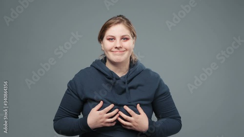 Video of stout woman touching breast in sweatshirt photo