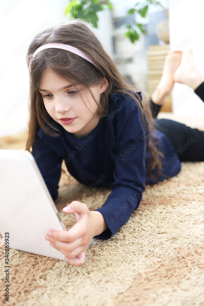 Homeschooling girl does homework at home in home interior. Online education during the quarantine. Homeschooling girl does homework at home in home interior. Online education during the quarantine.
