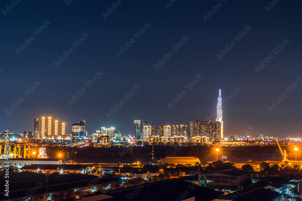 Urban night skyline panoramic view of Ho Chi Minh city. Ho Chi Minh City with development buildings, transportation, energy power infrastructure. View from District 7, Saigon. High resolution 