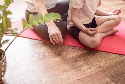 Mother and child are engaged in sports, doing exercises from yoga.