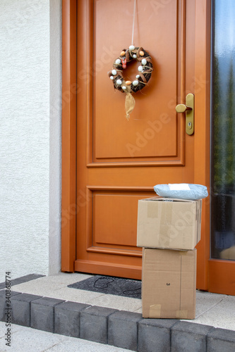 Coronavirus quarantine concept. Contactless delivery service of three packages placed at the door of house during pandemic. Stay at home and avoiding social contact and distance.