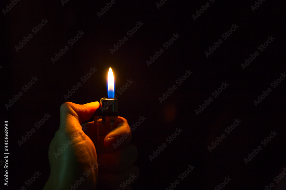 abstract Motion Hand with lighter igniting sparks on dark background abstract Motion Hand with lighter igniting sparks on dark background