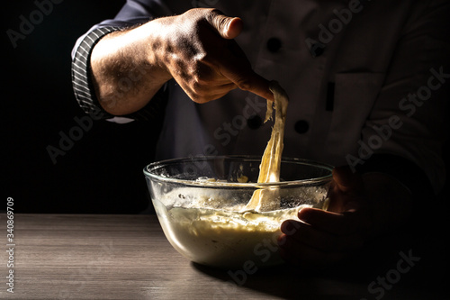 Chef-kok handen koken deeg op donkere houten achtergrond. Voedselconcept. Italië, eten, dieet en bio