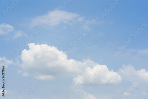 Blue sky with white soft clouds. Simple outdoor sky background.