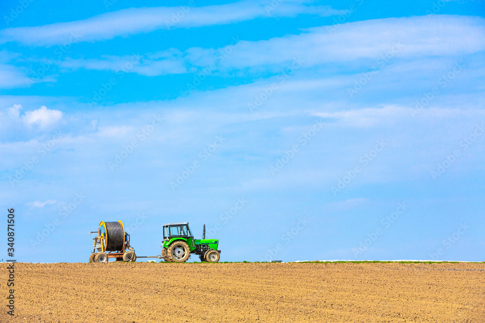 Fototapeta premium Traktor mit Anhänger auf dem Feld