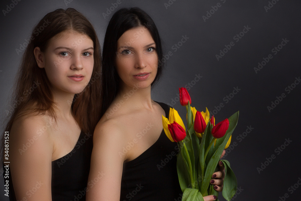 Fototapeta Portrait of girl and woman with tulips in the Studio