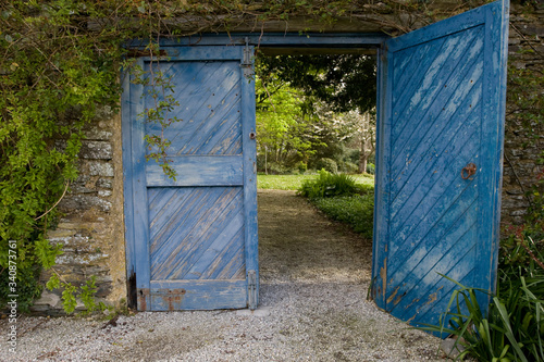 A set of blue wooden doors in a garden
