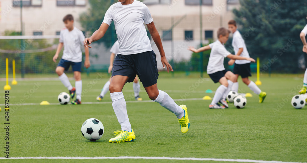 Soccer player on training field. Young boys in school soccer team on training session. Kids practice football. Junior level sports training