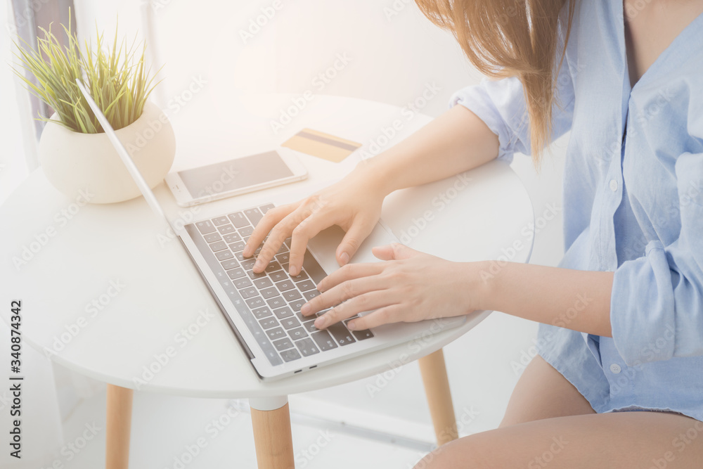 Fototapeta premium Hand of women Asian using a laptop while sitting working and shopping online at home, Asian women typing work from home