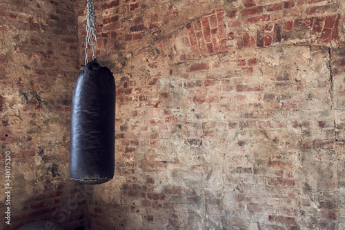 Gym in loft style, close-up of punching bag for boxing photo