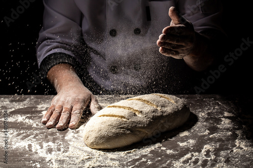 Fotografie, Tablou Baker making patterns on raw bread using a knife to shape the dough prior to baking
