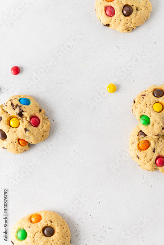 Sweet cookies with colorful candies for children on white background. Top view, copy space. Bakery, confectionery. Recipe