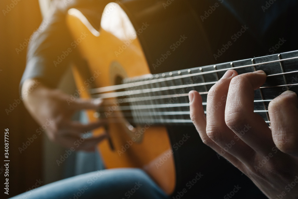 Obraz premium Man playing acoustic guitar. Practicing guitar. Modern young man playing.