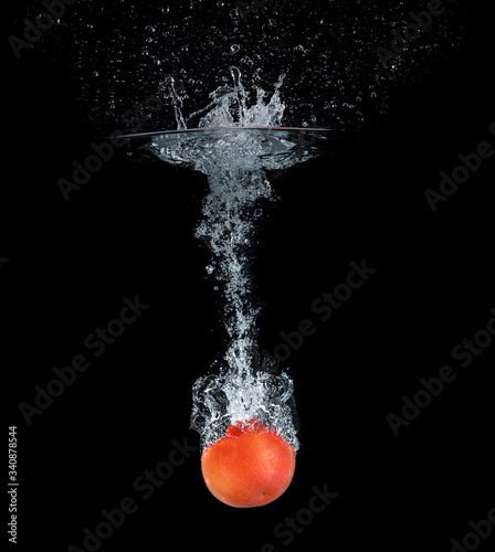 Tomatoes falling into the water