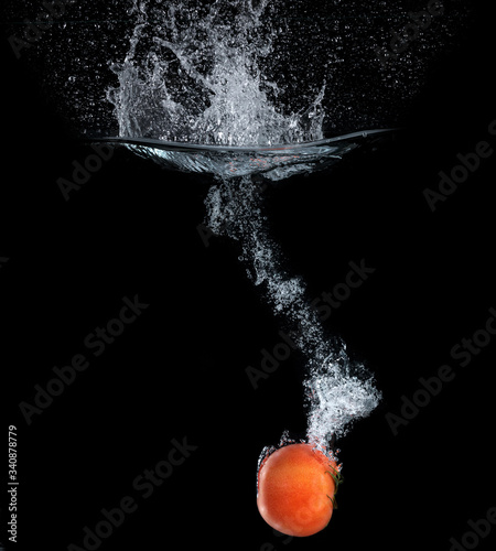 Tomatoes falling into the water
