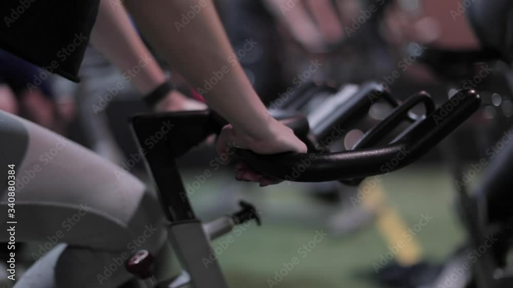 Girl in spin class holds onto the bike.