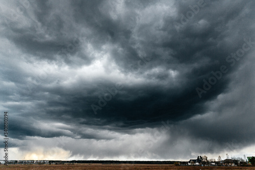 Dark storm clouds are gathering in the sky. Ominous dark sky with clouds. The beginning of a thunderstorm on the horizon. Moody weather.