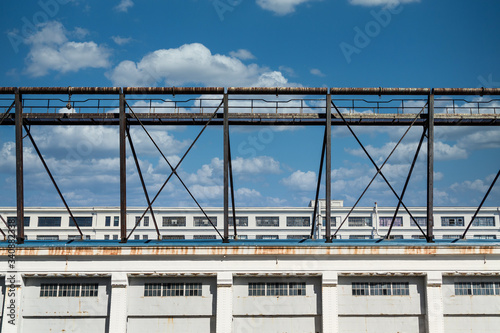 An old rusty metal walkway above an old white building with windows