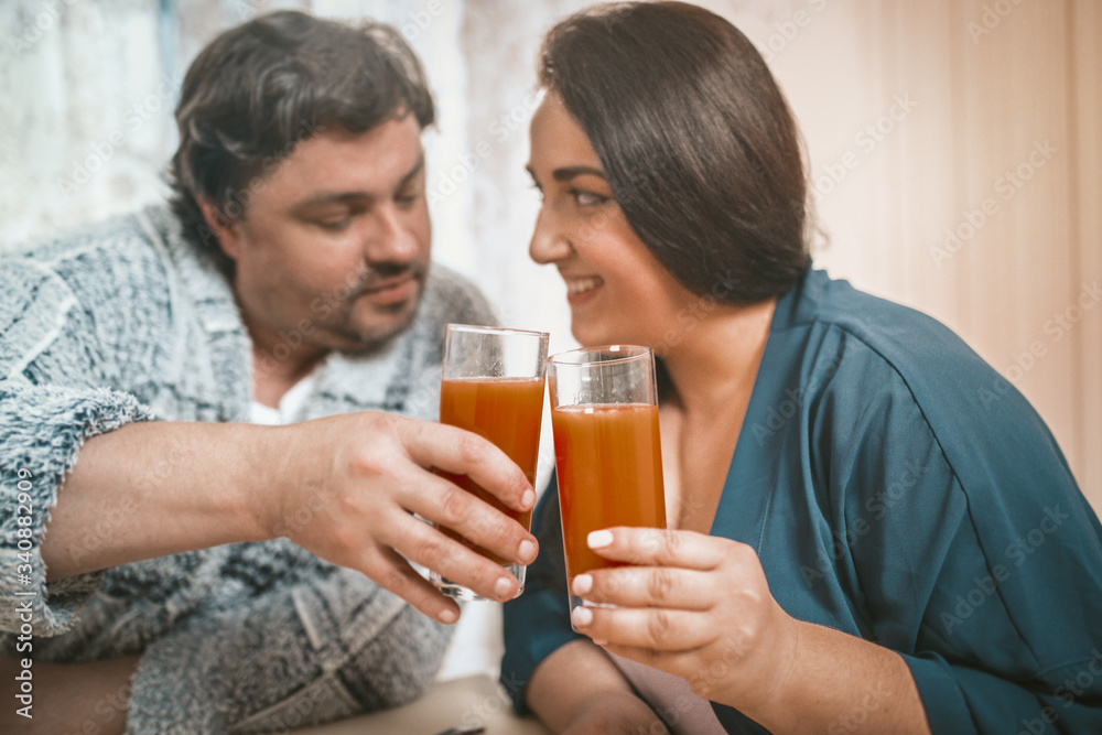 Couple Flirting And Clinking With Glasses Of Juice Couple Flirting And Clinking With Glasses Of Juice