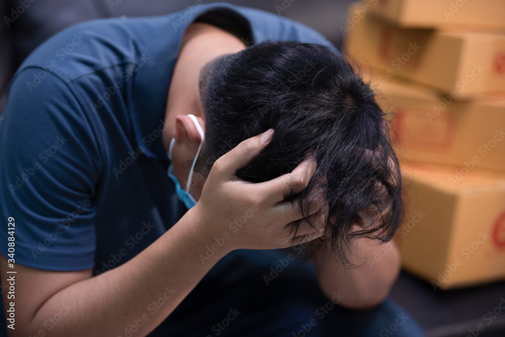 The young man is having a headache sitting on the sofa, the business concept failed to deliver The young man is having a headache sitting on the sofa, the business concept failed to deliver