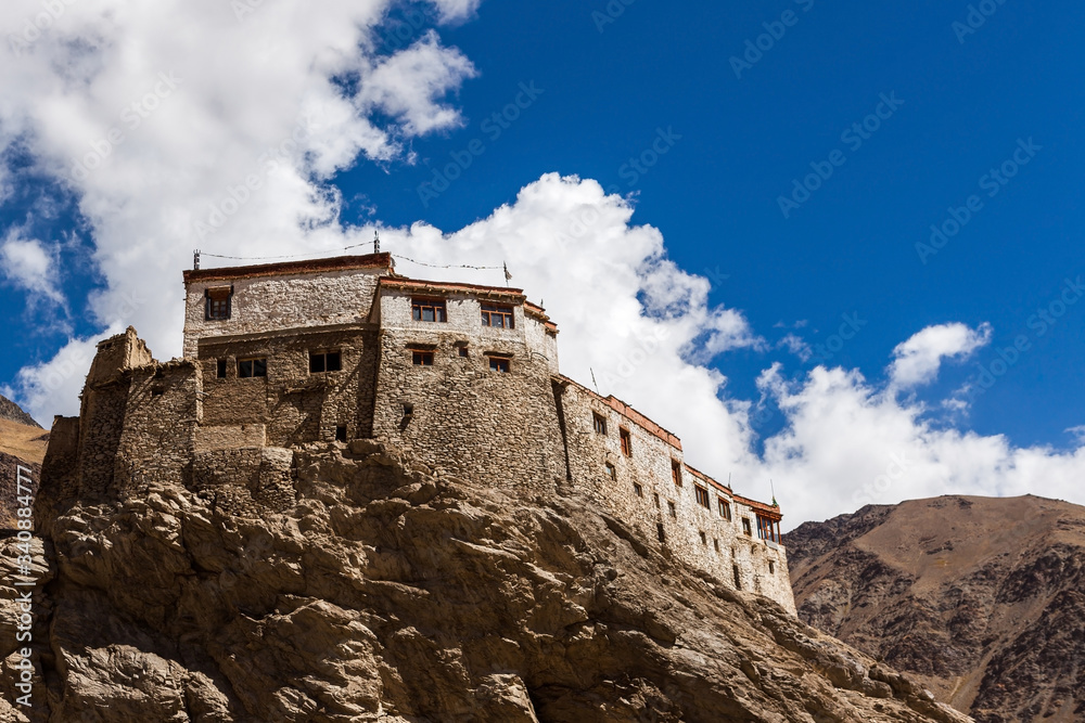 Tibetan buddhist monastery in Ladakh, Northern India. Tibetan gompa on a cliff with blue sky and mountains. Buddhist monastery in Nubra valley, Ladakh, India.