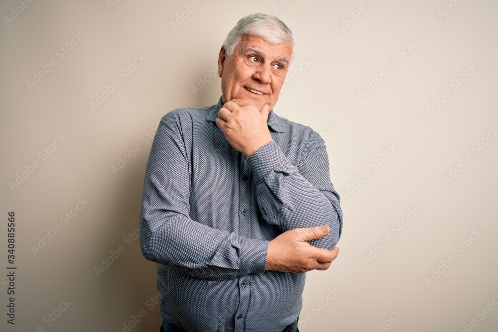 Senior handsome hoary man wearing casual shirt standing over isolated white background with hand on chin thinking about question, pensive expression. Smiling with thoughtful face. Doubt concept. Senior handsome hoary man wearing casual shirt standing over isolated white background with hand on chin thinking about question, pensive expression. Smiling with thoughtful face. Doubt concept.