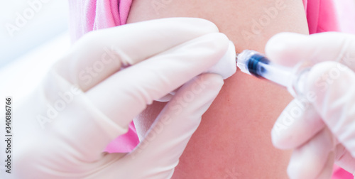 Doctor or nurses hand are adult vaccination to patient using the syringe injected upper arm for treated Doctor giving an injection to a patient Prophylactic HPV vaccin  flu  covid-19 and anal cancer.