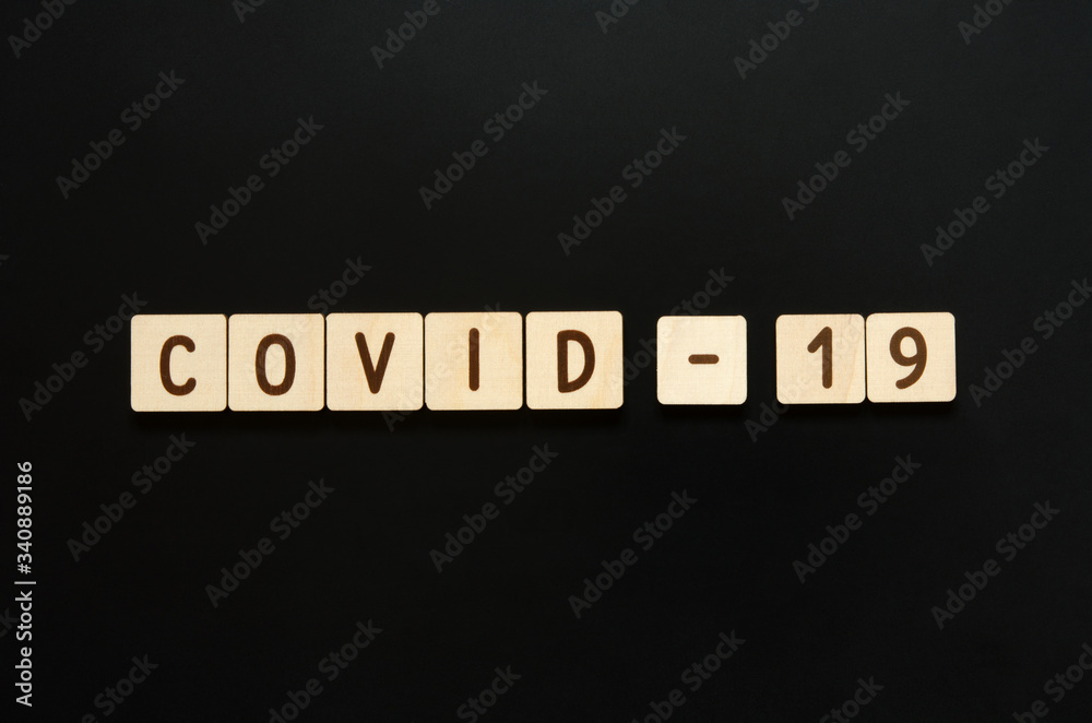 COVID-19 - words from wooden blocks with letters. Top view on black background. - Image COVID-19 - words from wooden blocks with letters. Top view on black background. - Image