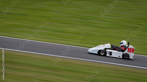 A panning shot of a white racing go-kart.