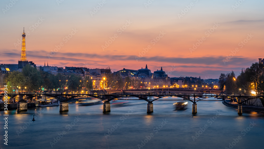 Pedestrian bridge (Pont des Arts) over Seine river and historic buildings of Paris France
