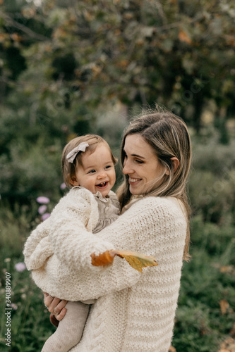 Smiling mother and daughter standing in park