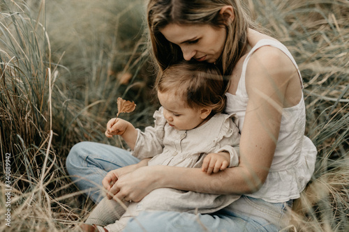 Mother and daughter sitting on grass in park