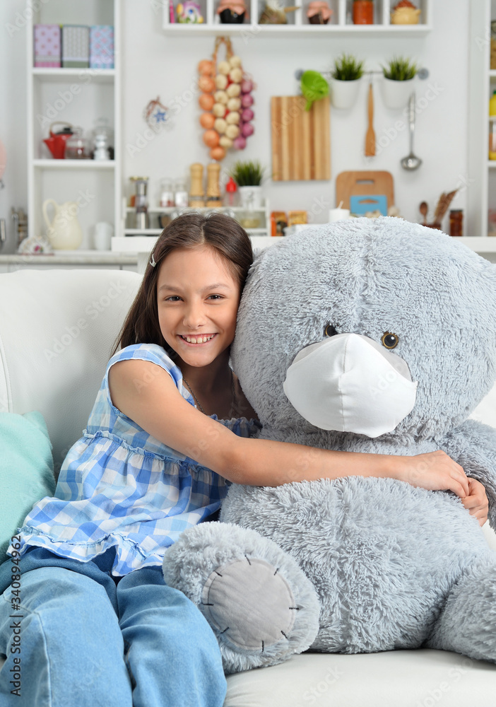 Happy little girl with toy teddy bear in facial mask Happy little girl with toy teddy bear in facial mask