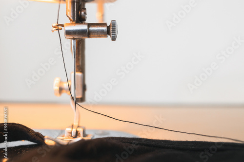 vintage sewing machine closeup detail needle black thread fabric