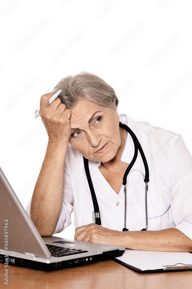 Confident female doctor sitting at table with laptop on white background Confident female doctor sitting at table with laptop on white background