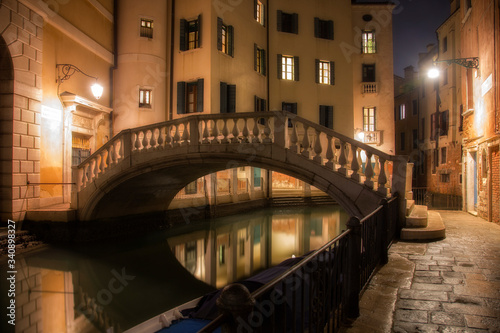 Houses along the canal and the bridge in Venice in night © Shchipkova Elena
