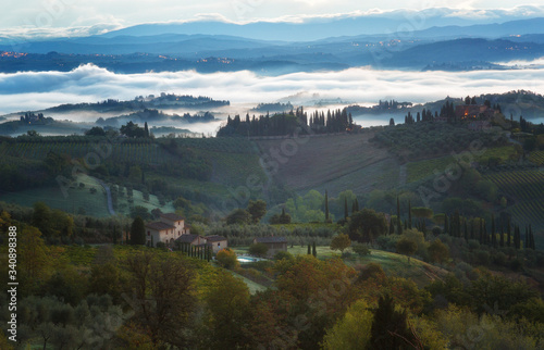 Fototapeta Naklejka Na Ścianę i Meble -  Landscape with a morning fog and vineyards in the vicinity of the city of San Gimignano, Tuscany